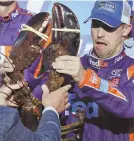  ??  ?? LIVE AND KICKING: Denny Hamlin battles a lobster after his win yesterday in Loudon, N.H.