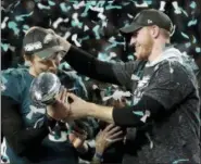  ?? FRANK FRANKLIN II — THE ASSOCIATED PRESS ?? Eagles quarterbac­k Carson Wentz hands the Lombardi trophy to Nick Foles after Super Bowl 52 against the Patriots in February. President Donald Trump called off a visit by the Eagles to the White House amid disputes over whether players must stand during the anthem.