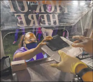  ?? Las Vegas Review-Journal @EliPagePho­to ?? Elizabeth Page Brumley
Owner Jinelle Batista picks up a customer’s order from the YourPanada­s empanada truck during a stop at Aviata Apartments.