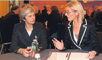  ??  ?? Prime Minister Theresa May meets Nora Smith, chief executive of CO3, at Queen’s University, Belfast yesterday. Left, arriving at QUB