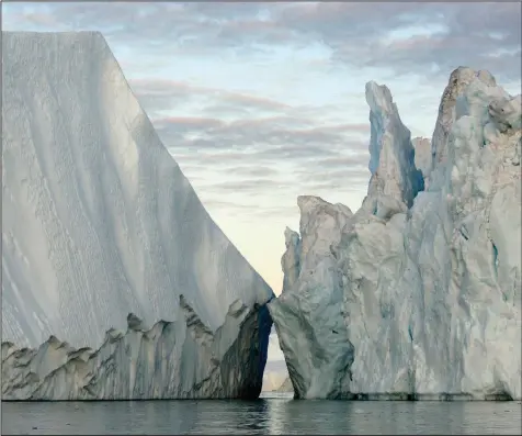  ?? (Extreme Ice Survey/James Balog) ?? In Disko Bay, Greenland, 20-story icebergs broken off from the Greenland Ice Sheet float into the North Atlantic, raising the sea level in this 2007 file photo. Will children born today live in a world with polar ice caps?