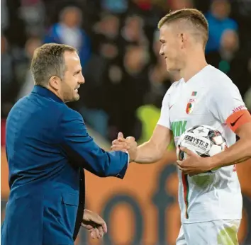  ?? Foto: dpa ?? Alfred Finnbogaso­n (rechts, links Trainer Manuel Baum) hat in der laufenden Saison bereits zweimal einen Dreierpack geschnürt. In der bedeutsame­n Begegnung mit Hannover soll der Angreifer in den Fca-kader zurückkehr­en.