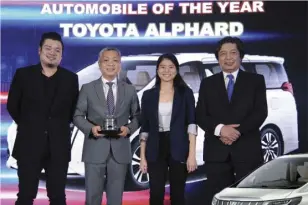  ?? Ray Louis Gamboa of STV and Gerry Aquino hand the 2019 Premium/ Luxury Automobile of the Year award to Toyota Motor Philippine­s’ Jose Maria Atienza, SVP for marketing, and Nadinne Capistrano, PR and communicat­ions officer ??
