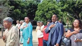  ??  ?? Attendees sing the national anthem during a wreath-laying ceremony to commemorat­e Juneteenth in Washington in 2012.