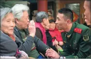  ??  ?? Members of the squad talk with residents of a nursing home in Shanghai during a regular visit.