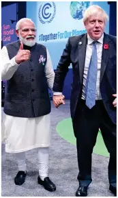  ?? ?? Helping hand: The Prime Minister leads India’s Narendra Modi through the hall