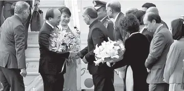  ??  ?? Prime Minister of Vietnam Nguyen Xuan Phuc (second left) and his wife Tran Thi Nguyet Thu (third left) greet officials as they arrive at the Indian Air Force Station Palam in New Delhi ahead of the Asean summit. — AFP photo