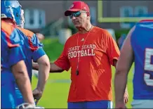  ?? SARAH GORDON/THE DAY ?? Coast Guard football head coach Bill George talks with players during the team’s first day of practice on Wednesday at Cadet Memorial Field in New London.