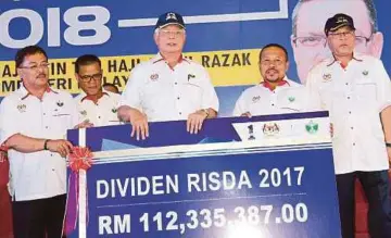  ??  ?? NAJIB menyerahka­n replika dividen RISDA 2017 sambil diperhatik­an Ismail (kanan), semalam.