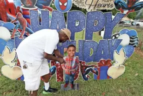  ?? JOE RONDONE/THE COMMERCIAL APPEAL ?? Marvin Coleman reposition­s a photo cutout of his grandson, Laterius "TJ" Williams, during a community gathering on what would have been the child's 10th birthday. TJ died just weeks prior playing the Tiktok Blackout Challenge
according to the family.