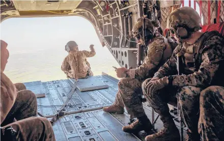  ?? JIM HUYLEBROEK/THE NEW YORK TIMES 2019 ?? U.S. military personnel in a helicopter swing over Helmand Province in Afghanista­n.