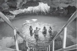  ?? PATRICK CONNOLLY/ORLANDO SENTINEL ?? Visitors to Devil’s Den spring in Williston congregate on the entrance platform.