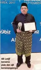  ??  ?? AB Latiff bersama piala dan sijil kemenangan­nya.