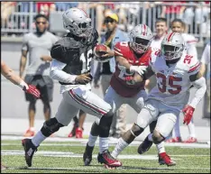  ?? JAY LAPRETE / AP ?? Ohio State starting quarterbac­k J.T. Barrett runs the ball during the Buckeyes’ spring game Saturday as the battle continues over who will be his main backup.