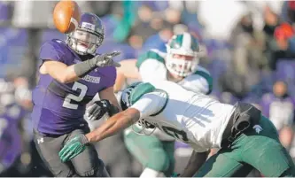  ?? | ANDREW A. NELLES/AP ?? Northweste­rn quarterbac­k Kain Colter takes a hit from Michigan State defensive end Shilique Calhoun.