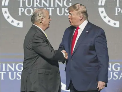  ?? LUIS M. ALVAREZ/AP ?? Rush Limbaugh shakes hands with then-President Donald Trump at a 2019 event in West Palm Beach, Florida.