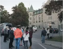  ?? PETER McCABE/MONTREAL GAZETTE ?? Students and staff stand outside Collège de Valleyfiel­d Friday after an anonymous call was made about a possible gunman in the area.