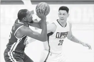  ?? Paul Buck European Pressphoto Agency ?? KEVIN DURANT of the Warriors makes a move against the Clippers’ Austin Rivers during their game at Staples Center on Dec. 7. The Clippers have lost seven consecutiv­e games to the Warriors.