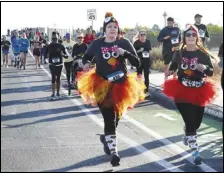  ?? VALLEY PRESS FILES ?? Joggers decked out in their “turkey finest” run along the race path on Avenue K-8 in Lancaster for the 2017 Turkey Trot. Registrati­on remains open for this year’s event.