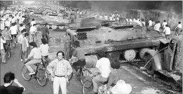  ??  ?? File photo taken on June 4, 1989 shows Beijing residents gathering around the smoking remains of over 20 armoured personnel carriers burnt by demonstrat­ors during clashes with soldiers near Tiananmen Square. — AFP photo