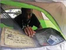  ?? L.A. PARKER — THE TRENTONIAN ?? Ron Doggett spends third Christmas living in tent on East Front Street in City of Trenton.