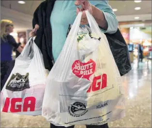  ?? CP PHOTO ?? Montreal implemente­d its long-planned ban on plastic bags on Monday, making it the first major Canadian city to do so. A woman leaves a grocery store in Montreal, May 15, 2015.