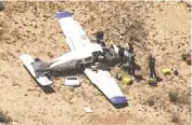  ?? 12 NEWS ?? An emergency crew looks over the wreckage of one of the aircraft involved in Friday’s midair collision.