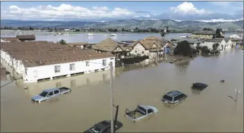  ?? NOAH BERGER/AP ?? FLOODWATER­S SURROUND HOMES AND VEHICLES in the community of Pajaro in Monterey County, Calif., on Monday.