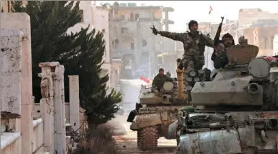  ?? SANA VIA REUTERS ?? Syrian army soldiers make their way through the town of Kafar Hamra in Aleppo Province on Monday.