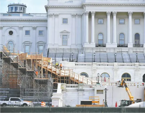  ?? MANDEL NGAN / AFP via Gett y Imag es ?? Workers construct the stage for the presidenti­al inaugurati­on at the U. S. Capitol in Washington, D.C.