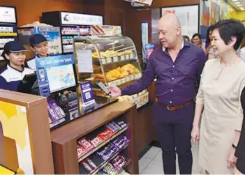  ??  ?? GLOBE president and chief executive officer Ernest Cu demonstrat­es to Robinsons Retail Holdings president and chief operations officer Robina Gokongwei-Pe how GCash QR works.