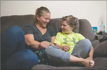  ?? NEWS-SENTINEL PHOTOGRAPH­S BY BEA AHBECK ?? Rebecca Lovato and her son Matthew Gress, 9, laugh together as they sit on the couch at the family’s Lockeford home on Friday.