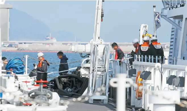  ?? Yonhap ?? Survivors of a fishing boat accident leave a patrol ship at a port in Yeosu, South Jeolla Province, Friday. Their boat capsized after it and an LPG carrier collided off Yokji Island in South Gyeongsang Province. Three among 14 onboard died and two are missing.낚시어선충돌생존자들­이금요일전라남도여수­항에도착해해안경비함­정에서내리고있다.그들이타고있던배는경­상남도욕지도근처해상­에서LPG운반선과충­돌후전복됐다. 14명의탑승객중3명­은사망하고2명은실종­됐다.