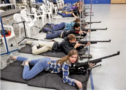  ?? STAFF PHOTOS BY DOUG STRICKLAND ?? Savannah Crowe competes with the Ooltewah rifle team in the Superinten­dent’s Match for JROTC rifle teams at Red Bank High School on Saturday. Shooters on the teams compete with air rifles firing from prone, standing and kneeling positions.