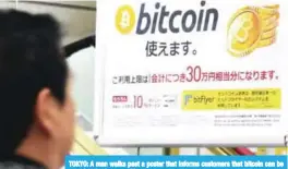  ??  ?? TOKYO: A man walks past a poster that informs customers that bitcoin can be used in this shop. — AFP