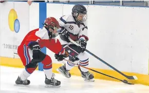  ??  ?? Dundee Stars’ U/14 player Lachlan McMillan battles along the boards with his Edinburgh marker.