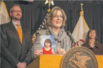  ?? | RICH HEIN/ SUN- TIMES ?? Chris Newlon brought a photo of her daughter Rebecca, 13, to the ABLE news conference Monday, also attended by state Treasurer Michael Frerichs ( left).