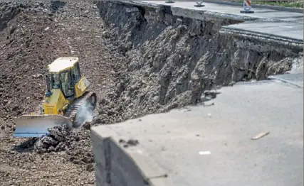  ?? Steph Chambers/Post-Gazette ?? Work takes place after the landslide that destroyed a section of Route 30 in East Pittsburgh in April 2018.