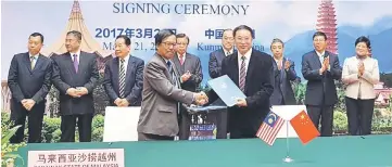  ??  ?? Hatta (left) and Yang exchange MoU documents while Abang Johari (centre) and others look on.