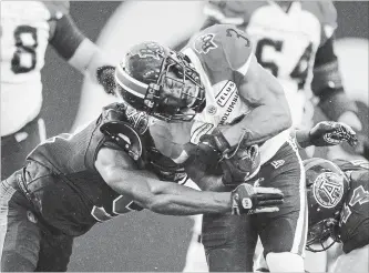  ?? ANDREW LAHODYNSKY­J THE CANADIAN PRESS ?? B.C. running back John White IV, centre, gets tackled by Argonauts long snapper Joe Spaziani and Ian Wild.