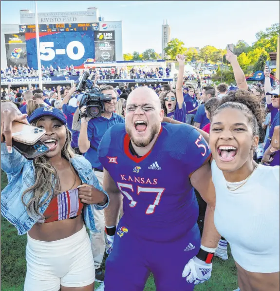  ?? Reed Hoffmann The Associated Press ?? Kansas offensive lineman Hank Kelly and fans celebrate after a 14-11 victory Saturday against Iowa State that landed the 5-0 Jayhawks in the AP Top 25 for the first time in 13 years. Ranked 19th, Kansas plays TCU this Saturday.