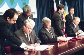  ?? LAPRESSE/ANSA ?? Dall’est all’ovest Eltsin, Clinton e Kutchma firmano il Trattato di non proliferaz­ione nucleare 1994; in basso, vittime di un raid aereo ucraino nel Donetsk nel 2014