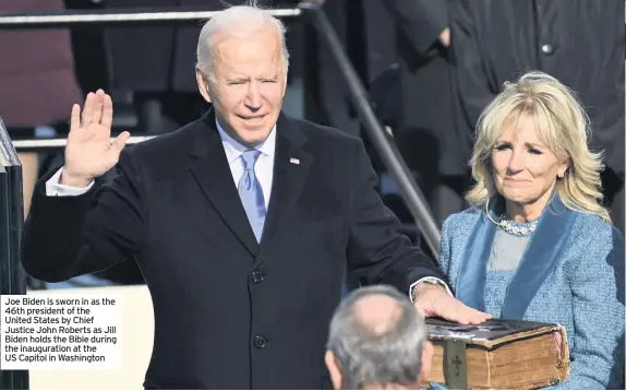  ??  ?? Joe Biden is sworn in as the 46th president of the United States by Chief Justice John Roberts as Jill Biden holds the Bible during the inaugurati­on at the US Capitol in Washington