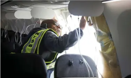  ?? Photograph: NTSB via AP ?? In this photo released by the National Transporta­tion Safety Board, NTSB investigat­or-in-charge John Lovell examines the fuselage plug area of Alaska Airlines Flight 1282 on 7 Jan.