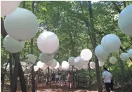  ?? SAMANTHA WEST/MILWAUKEE JOURNAL SENTINEL ?? Art installati­ons at the 2018 Eaux Claires, like this collection of balloons in the woods, allowed for fan interactio­n.