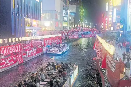  ??  ?? Infierno encantador en Japón. Los hinchas de Independie­nte tomaron el centro de Osaka.