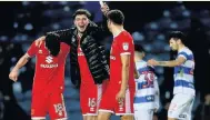  ??  ?? JUBILANT MK Dons players after third-round win at QPR