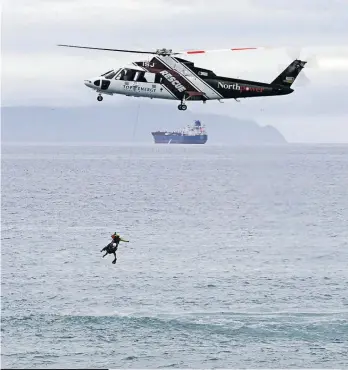  ?? Photo / John Stone ?? A Nest helicopter at Uretiti Beach in a display to highlight water safety.