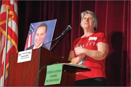  ?? PHOTOS BY MARIAN DENNIS – DIGITAL FIRST MEDIA ?? Tammy Harkness, an organizer of Saturday’s town hall meeting, stands next to a photo of U.S. Rep. Ryan Costello, R-6, who was invited to the meeting but could not attend because of scheduling conflicts.