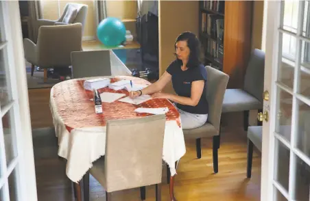  ?? Lea Suzuki / The Chronicle ?? Debbie Raucher, an organizer with Swing Left, works on a political letterwrit­ing campaign at her Oakland home.